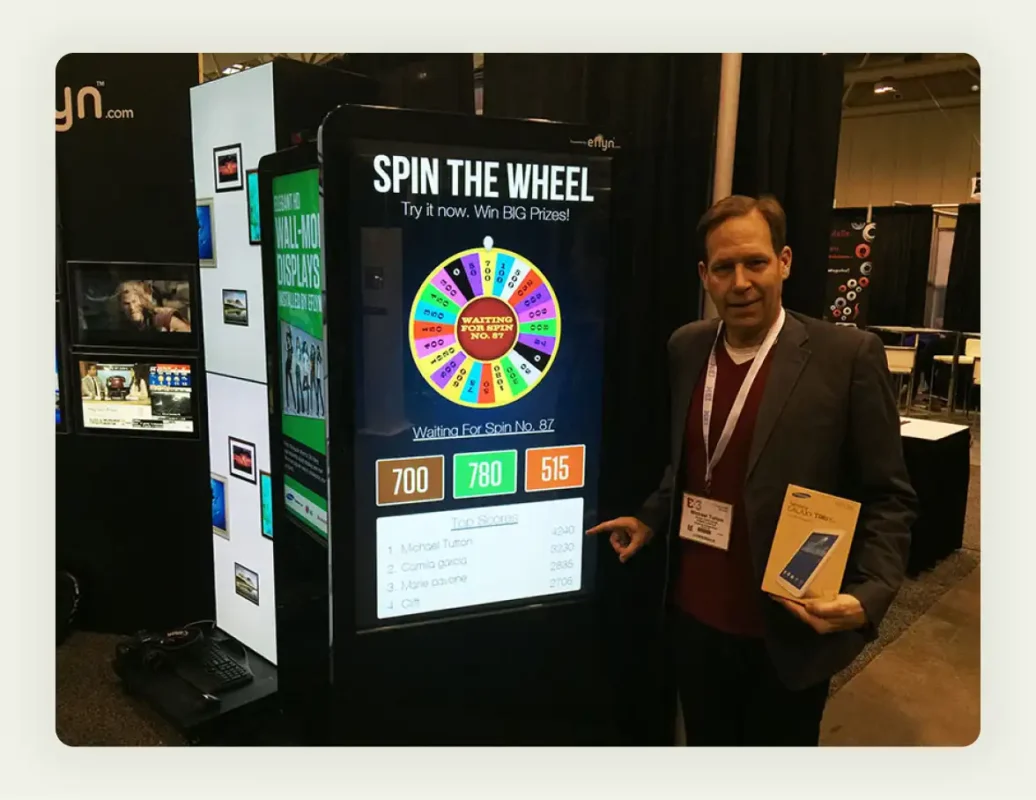 Colorful spin-to-win prize wheel at trade show booth with excited attendees participating